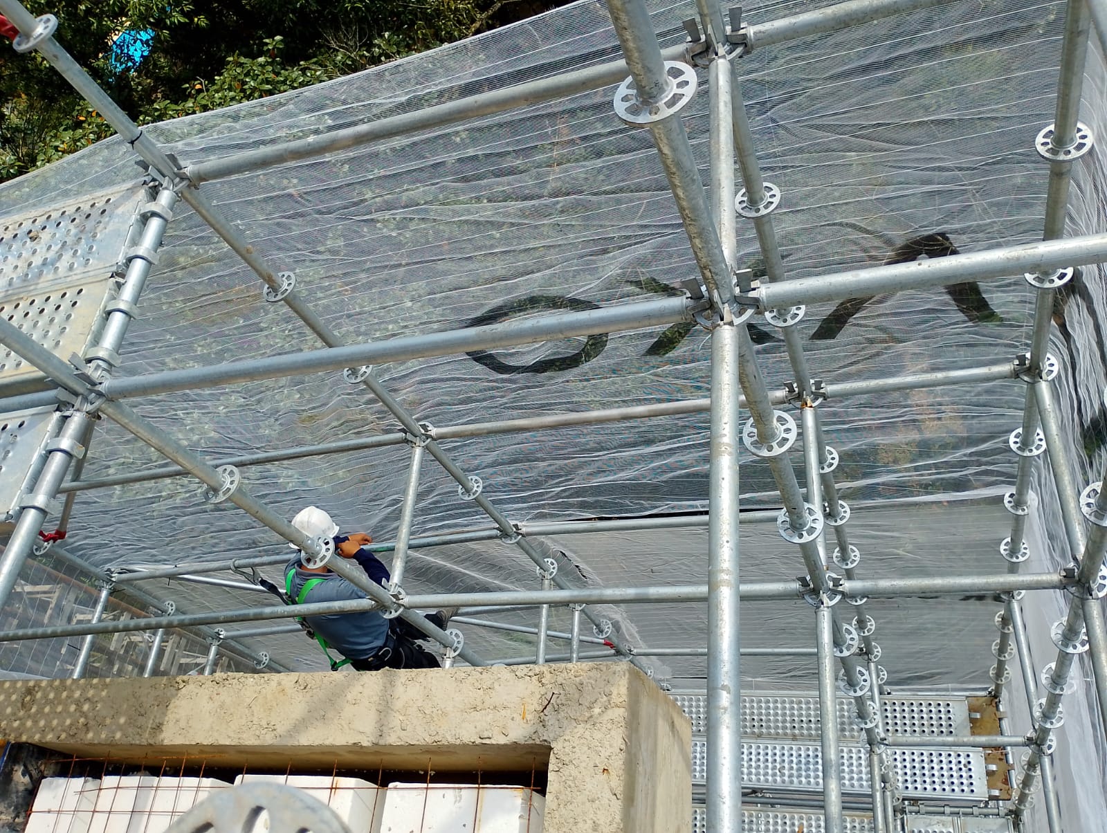 Trabalho em andaime com tela fachadeira instalada